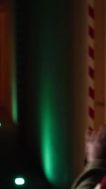 Atış poligonunda tabancayla eğitim gören dikey videolu kadın kağıt hedefle ilgili sonuçlara bakıyor. Afrikalı Amerikalı atıcılık sporu yapıyor, keskinleştirme becerileri, kontrol puanları tam on ikiden