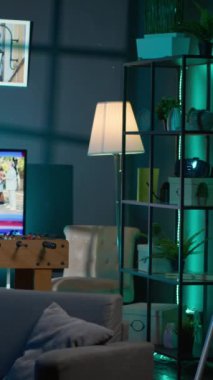 Neon ışıkları, büyük bir televizyon ve genç bir yetişkin için ev sineması ile aydınlatılmış dikey Video Cozy lüks dairesi. Elektronik aletlerle donatılmış boş bir çatı katı, rahat bir yer..