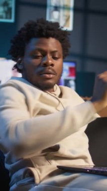 Dikey Video Siyah Serbest Çalışmacısı araştırmasını yeni bir proje için bilgi toplamak amacıyla telefon ve bilgisayar kullanarak evde makaleler ve veri odaklı kağıtlar okuyarak yapıyor. Adam birden fazla görev yapıyor ve dosyaları inceliyor