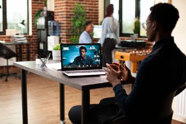 Bir müşteriyle video konferansı düzenleyen erkek girişimci, pazarlama stratejilerini hayata geçirmeye odaklanıyor. Siyahi işadamları online bir toplantıda, kalkınma planlarını ve proje stratejilerini gözden geçiriyorlar.