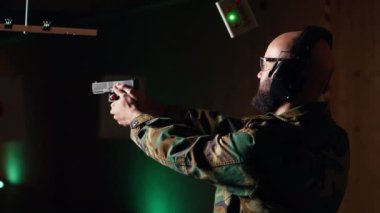 Atış talimi yapan mutlu bir adamın portresi, silah tutma adabını öğrenmesi, uzun menzilli hedeflerle çatışması. Sevinçli asker ölümcül ateş ediyor, kamera B