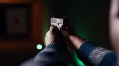 Atış poligonu müşterisi tabancayla ateş ediyor. Hedefe ateş edip etmediğini kontrol ediyor. Atış poligonunda silah kullanmayı öğrenen, hedeflerin görüntülerini analiz eden, kamera B