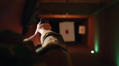 Atış poligonunda eğlence amaçlı atış deneyimi olan bir adam, hedef tahtası olup olmadığını kontrol ediyor. Atış poligonu şirketinde silahlarla pratik yapan kişi, hedef vurma, kamera A