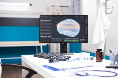 Nörolojik analiz teknolojisini vurgulayan beyin görüntüleme ve taramaları gösteren masaüstü bilgisayarlı klinik ofisi. Tıbbi dosyalara, ekran verilerine ve ekipmanlara odaklanmaya izin veren kimse yok.