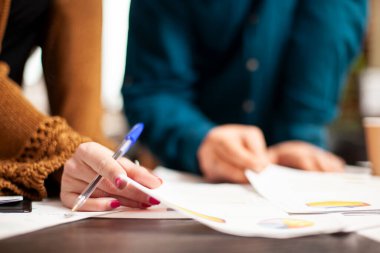 Ofisteki şirket araştırma belgelerini inceleyen Kafkasyalılara odaklan. Girişimcilik şirketinde mali evrakları tutan ve araştıran erkek ve kadın meslektaşların ellerinde..