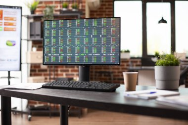 Şirket istatistiklerini, finansal grafiklerini ve ticaret araçlarını gösteren masaüstü bilgisayarı olan boş modern çalışma alanı. Organize ofis malzemeleri ve bitki dekorasyonu profesyonel kurulum oluşturur.