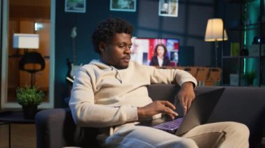 Siyahi adam araştırmasını makaleleri okuyarak ve evde notlar alarak, yeni bir proje için bilgi toplayarak yapıyor. Freelancer birden fazla iş yapıyor ve veri odaklı kağıtlarla dosyaları inceliyor. Kamera B.