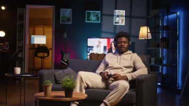 Sıkılmış adam çevrimiçi video oyunu oynuyor ve modern dairesindeki saldırı tuşlarına spam atıyor. İnternet ve spor müsabakalarına katılan neon ışıklı uzay oyuncusu. Kamera B.