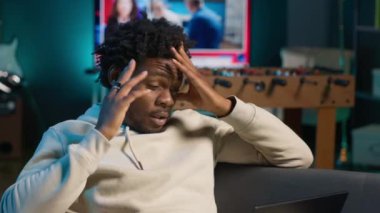 Siyahi birinin baş ağrısı ve mide bulantısından muzdarip olması oturma odasında oturması ve görevler üzerinde çabalaması. Evde hastalıktan muzdarip uzaktan çalışan işçi. Kamera A.