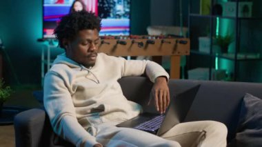 Genç siyahi kişi programları denetliyor ve evindeki faaliyetleri planlıyor, online araçlarla zaman yönetimi üzerinde çalışıyor. Yetişkin bir erkek bilgisayarda takvim kullanıyor ve planlayıcıyı kontrol ediyor. Kamera A.