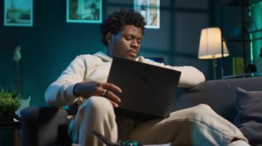 Siyah uzaktan kumandalı işçi diyabetten muzdarip ve evde glukometre kullanıyor, kan örneğiyle şeker seviyesini kontrol ediyor. Genç yetişkin glikoz ölçümü için insülin kalem kullanıyor. Kamera A.