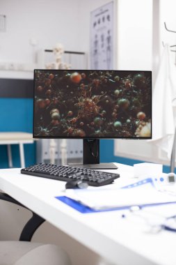 Hastalık araştırmalarına adanmışlığı temsil eden, salgın hücreli germ hücreli masaüstü bilgisayarlı boş bir tıp bürosu. Temiz doktorların çalışma alanı dijital tedavi çabalarını destekliyor.