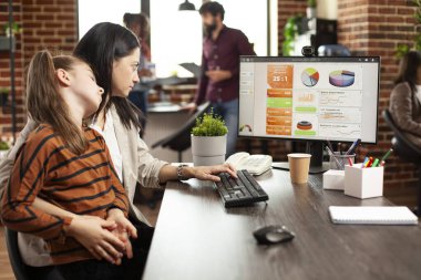 Kızı kucağında uyuyan kadın finans analisti, çizelgeleri ve şirket büyüme ölçülerini gözden geçiriyor. Profesyonel anne, yanında küçük kızıyla bilgisayardan mali verileri kontrol ediyor..