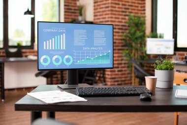 Başlangıç şirketi bilgileri bilgisayar ekranında analistin boş tuğla duvar odasını incelemesi için hazır. Çalışanlar tarafından kullanılmaya hazır, masaüstü bilgisayarı veri araştırması gösteren boş bir iş bürosu.