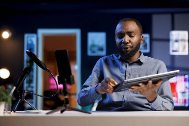 Stüdyodaki nüfuzlu kişi canlı yayın yapmak ve dizüstü bilgisayarı incelemek için akıllı telefonu kullanıyordu. Çevrimiçi şov sunucusu, cep telefonu kamerası kullanan izleyicilere not defteri sunuyor.