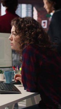 Uygulamalar oluşturmak için bilgisayardaki programlama dillerini kullanan dikey video Happy çalışanı. Neşeli bilişim uzmanı yazılım geliştirme ajansındaki bilgisayarı kodlamak için kullanıyor, kamera A