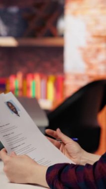 Dikey video teknisyeni HR çalışanı iş açılışı için adayları analiz ediyor, yetenekleri belirlemek için özgeçmişleri gözden geçiriyor. Silikon Vadisi şirketinin pozisyonu için insanları tarayan kadın