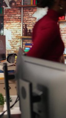 Dikey video Irked man uygulama hatalarını düzeltmeye çalışırken hayal kırıklığı içinde ofis masasını yumrukluyor. Yazılım geliştirme ajansında kodlama yaparken bilgisayar hatalarından rahatsız olan programcı, kamera