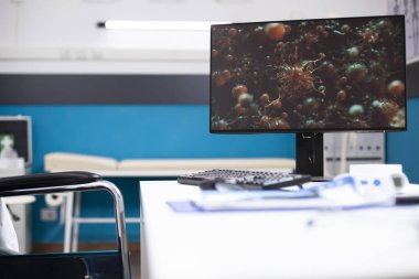 Masaüstü monitörlü doktorların ofisi hücre görüntülerini gösteriyor, salgın hastalıklar için sağlık hizmetlerini sembolize ediyor. Bilgisayarlı boş klinik odası. Grip virüslerinin gelişmiş dijital tedavisine hazır..