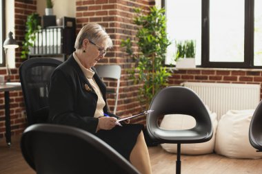 Gözlüklü kıdemli psikiyatrist, panodaki notları inceliyor, etrafı düzenli sandalyelerle çevrili. Emekli kadın tuğla duvar odasında tek başına kitap okuyor, akıl sağlığı ve hasta bakımına kendini adamış..