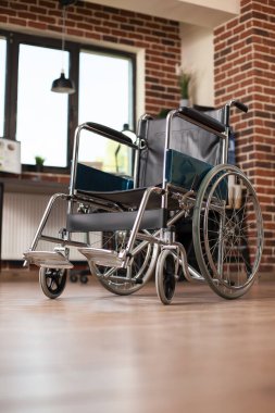 Ulaşılabilirlik için tasarlanmış tuğla duvar ofisi, düzgün düzenlenmiş masa, raflar ve tekerlekli sandalye yerleştirme ile. Modern çalışma alanında erişilebilirliği sağlamak için raflar ve mobilyalarla düzenlenmiş boş bir oda.