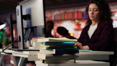 Girişimciler tarafından iş geliştirme ve öğrenim için kullanılan yeni açılan ofis masasına istiflenmiş kitapları kapatın. Risk şirketi yöneticisinin araştırma yapmak için kullandığı kitap yığınına odaklan, kamera B
