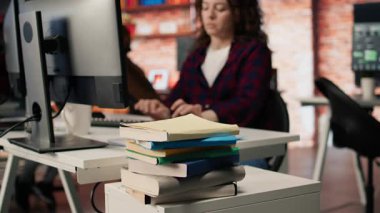 Girişimciler tarafından iş geliştirme ve öğrenim için kullanılan yeni açılan ofis masasına istiflenmiş kitapları kapatın. Risk şirketi yöneticisinin araştırma yapmak için kullandığı kitap yığınına odaklan, kamera A