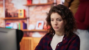 Bilgisayar monitörlerinde şirketin güvenlik açığını arayan bir siber güvenlik uzmanı. Yazılım geliştirme ajansı programcısı B kamerasına güçlendirilmiş kod yüklüyor