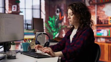 Uygulamaları oluşturmak için bilgisayardaki bilgisayar programlama dillerini kullanan mutlu bir çalışan. Neşeli bilişim uzmanı yazılım geliştirme ajansında kodlamak için bilgisayar kullanıyor, kamera B