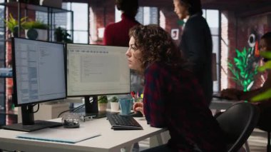 Uygulamaları oluşturmak için bilgisayardaki bilgisayar programlama dillerini kullanan mutlu bir çalışan. Neşeli bilişim uzmanı yazılım geliştirme ajansındaki bilgisayarı kodlamak için kullanıyor, kamera A