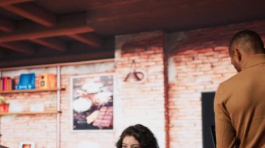 Yeni başlayan bir çalışan işe defterle geliyor, hataları düzeltmek için kod incelemesi yapıyor, teknik sorunları tanımlıyor. Yapay zeka çalışanı ofise dizüstü bilgisayar ve kamera A ile geliyor.