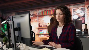 Uygulama geliştirmek için programlama dilleri kullanan, yenilikçi bir girişim ofisinde çalışan bir çalışan. Yazılım geliştirme ajansı bilişim uzmanı kodu optimize ediyor, bilgisayar klavyesinde daktilo ediyor, kamera A