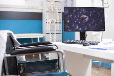 Boş doktorların ofisindeki virüs hücrelerinin dijital görüntüsü hastalıklara karşı sağlığa verilen tepkiye odaklanıyor. Mikroskobik mikroplar sergilenen masaüstü bilgisayarı, tekerlekli sandalye erişilebilir masasında araştırma için hazır..