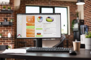 Masası sunumlar için hazırlanmış tuğla duvar ofisi analitik ve organize belgeleri gösteren bir bilgisayar tutuyor. Şirket araştırma verilerini gösteren masaüstü bilgisayarı evrak işleriyle dolu düzenli bir masanın üzerine yerleştirilir.