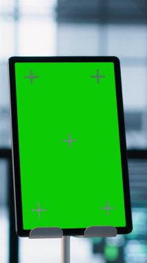 Bulanık arka planda sunucu çiftliğinde çalışan teknisyenlerin önünde verileri analiz eden dikey ekran modelleme tableti. Veri merkezini inceleyen iş arkadaşlarının yanına krom anahtar tabletini kapat