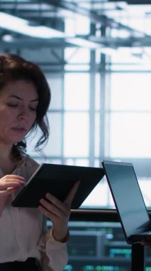 Veritabanında dizüstü bilgisayar kullanan, sunucu viralizasyonunu yöneten dikey videolar. Neşeli bilişim uzmanı ve Afro-Amerikalı sunucu odasında bilgisayar kullanarak altyapıyı sağlama alıyor.