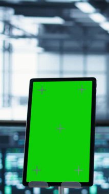 Afet kurtarma planları geliştiren tablet ve veri merkezi mühendislerinin dikey videosu. Sunucu çiftliği meslektaşlarının önündeki izole ekran cihazına odaklan.