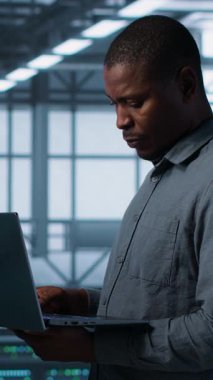 Güvenlik duvarı yapılandırmalarını doğrulayan cihazlar kullanarak veri merkezindeki mutlu sistem yöneticilerinin dikey video portresi. Jolly takım çalışması bilişim uzmanları sunucuda ekipman savunmasızlığı taraması yapıyor