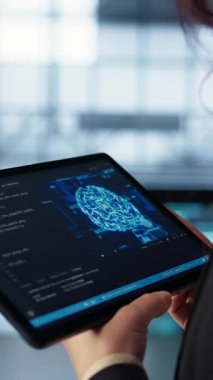 Dikey Veri Merkezi teknisyeni savunmasızlığı önlemek için tablet üzerinde yapay zeka kullanıyor. Çalışan güvenlik duvarı kurallarını gözden geçirmek için aygıt kullanıyor, yapay zeka siber güvenlik protokollerini uyguluyor, kamera B