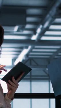 Veri merkezindeki dikey video meslektaşları enerji kullanımını ayarlamak için dizüstü bilgisayar kullanır. UPS ayarlarını denetlemek için dizüstü bilgisayar kullanan sunucu çiftliği bilişim uzmanı, ekipman ve kamera bakımı yapıyor