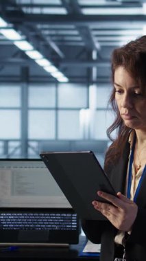 Yeni sunucu mimarileri oluşturmak için tablet üzerindeki yapay zeka teknolojisini kullanarak veri merkezindeki dikey video yönetimi. Sunucu odasındaki kadın sabit performansı korumak için depolama dizilerini güncelliyor, kamera