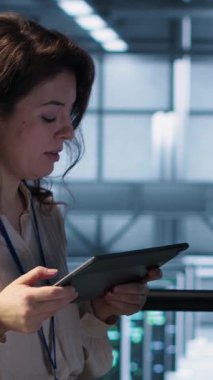 Sunucu çiftliğinde çalışan teknisyenlerden oluşan dikey video ekibi verileri analiz etmek için dizüstü bilgisayar kullanıyor. Veri merkezindeki altyapıyı inceleyen ekip çalışanları, sistem bütünlüğü ve güvenliği sağlıyorlar, kamera A