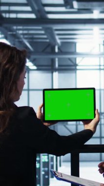 Sunucu çiftliğindeki dikey video sistemi yöneticileri ayarları doğrulamak için izole ekran model tableti kullanıyorlar. Veri merkezi meslektaşları yeşil ekran kroma anahtar aygıtı kullanarak tesisi, kamera B 'yi izliyorlar.