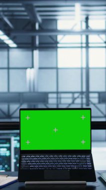 Veri merkezindeki dikey video çalışanları yeşil teknolojileri entegre etmek için model dizüstü bilgisayar kullanıyorlar. Sürdürülebilir enerji çözümleri uygulamak için krom anahtar defteri kullanan sunucu odasında bilişim uzmanları, kamera B