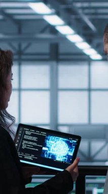 Dikey video veri merkezi teknisyenleri tablet kullanarak yapay zeka kullanan yönetim araçları kullanıyorlar. Sunucu çiftliği iş arkadaşları sunucu kümelerini denetliyor, ağ topolojilerini yapay zeka kullanarak güncelliyor