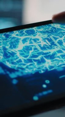 Veri merkezindeki bilgisayar bilimcisinin dikey videosu, rafların uyumunu doğrulamak için tablet üzerinde yapay zeka kullanıyor. Kaynak kullanımını optimize etmek için aygıt üzerinde yapay zeka kullanan bilişim uzmanı