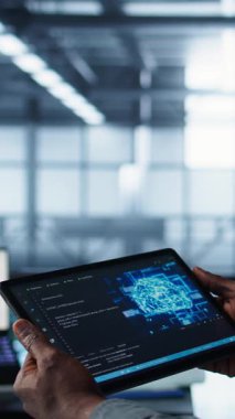 Veri merkezindeki bilgisayar bilimcisinin dikey videosu, rafların uyumunu doğrulamak için tablet üzerinde yapay zeka kullanıyor. Kaynak kullanımını optimize etmek için aygıt üzerinde yapay zeka kullanan bilişim uzmanı