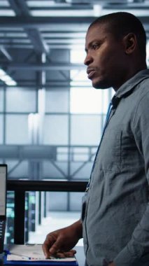 Bilgisayarda ve tablette yapay zeka kullanan dikey video veri merkezi bilgisayar bilimcileri. Sunucu odası çalışanları, hesaplama işlemleri için aygıtlar üzerinde sinirsel ağlar kullanırlar.