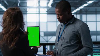 Veri merkezinde yeşil ekran tableti kullanan mühendisler altyapının güvenilirliğini kontrol ediyor, panoya yazı yazıyorlar. Sunucu odasında modelleme aygıtı kullanan işçiler, sunucu viralizasyonunu yönetenler, kamera A