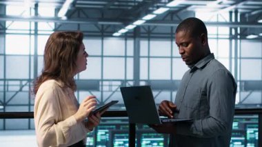 Veri merkezinde bilgisayar ve tablet kullanan geliştiriciler, güvenlik yamalarını çalıştıran, güvenlik duvarını koruyan. Sunucu tarım işçileri güvenlik taraması yapmak için aygıtlar kullanıyor, veri koruması sağlanıyor, kamera A